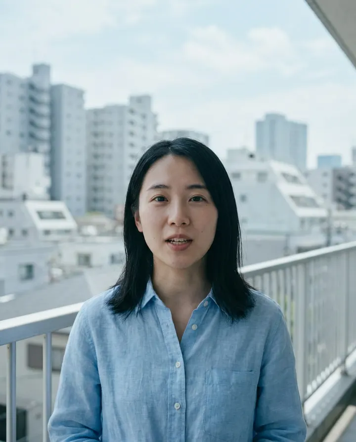 A creator in a light blue shirt talking to camera on a city balcony, a frame from a regional creator account