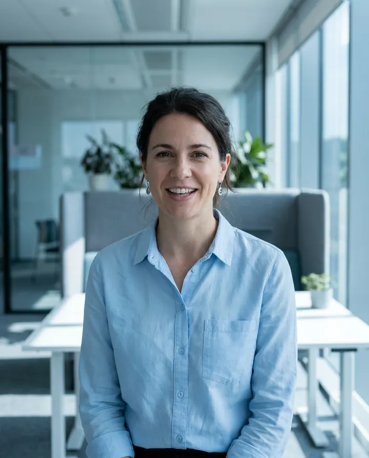 A presenter in a light blue shirt speaking to camera in an office, a frame from a sales outreach video