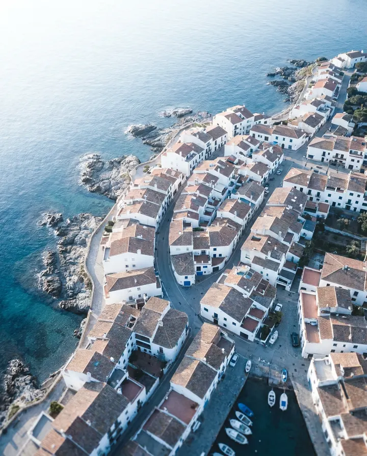 An aerial view of a white coastal village above blue sea, a frame from a video made from a travel article