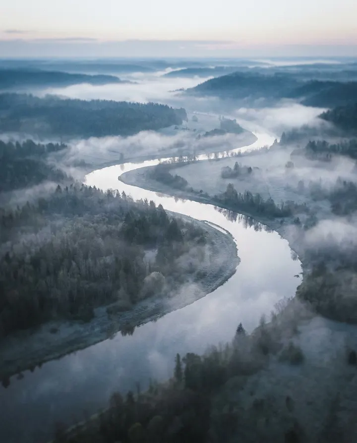 An aerial shot of a misty river valley at dawn, a frame from a long-form narrated YouTube video