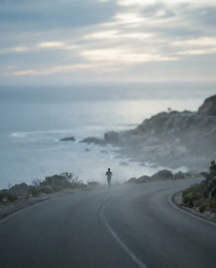 A runner on a coastal road at sunrise, a frame from a motivational video