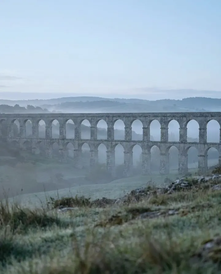 A Roman aqueduct in morning haze, a frame from a cinematic AI history story TikTok